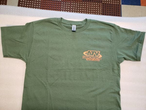A green t-shirt with a brown logo on it.