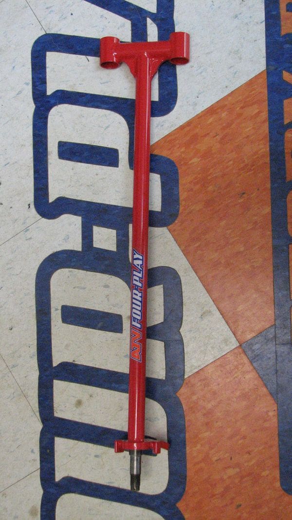 A red stick on the floor of an indoor area.