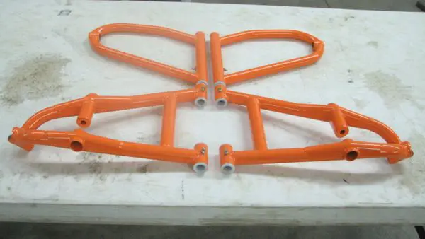 A pair of orange motorcycle frames sitting on top of a table.