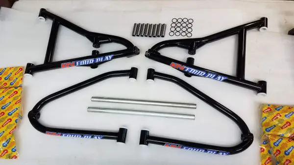 A set of four black motorcycle frames with some springs and bars.