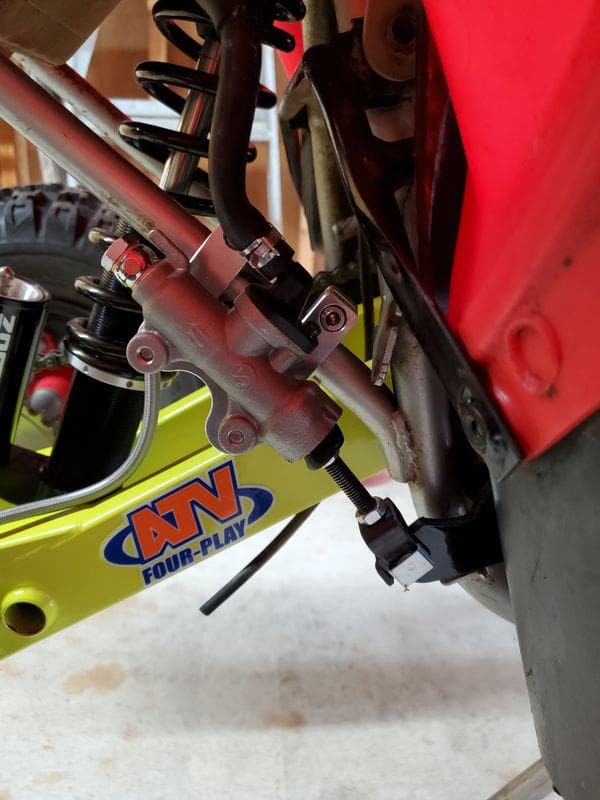 A close up of the front forks on a dirt bike.
