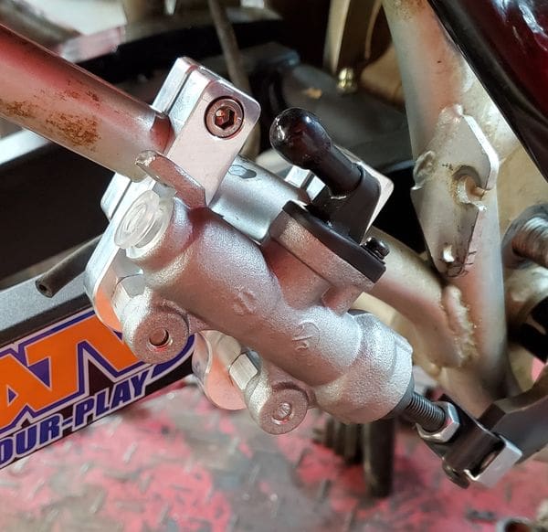 A close up of the brake and clutch pedal on a motorcycle.