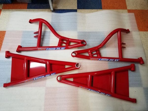 A red motorcycle frame sitting on top of the floor.