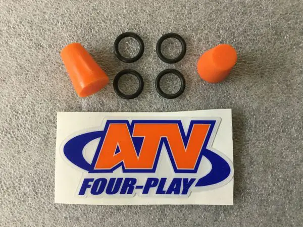 A pair of orange ear plugs and an atv four play sticker.