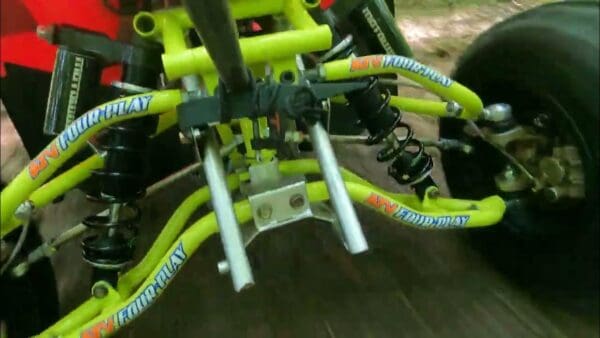 A close up of the front forks on a yellow bike.